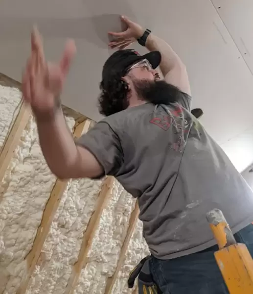 Circle I Enterprises crew member installing drywall over fresh insulation