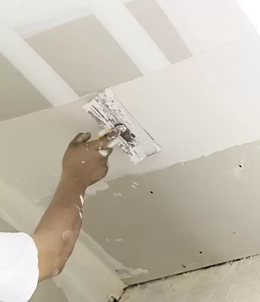 Finishing a ceiling seam by hand with a trowel for a seamless result
