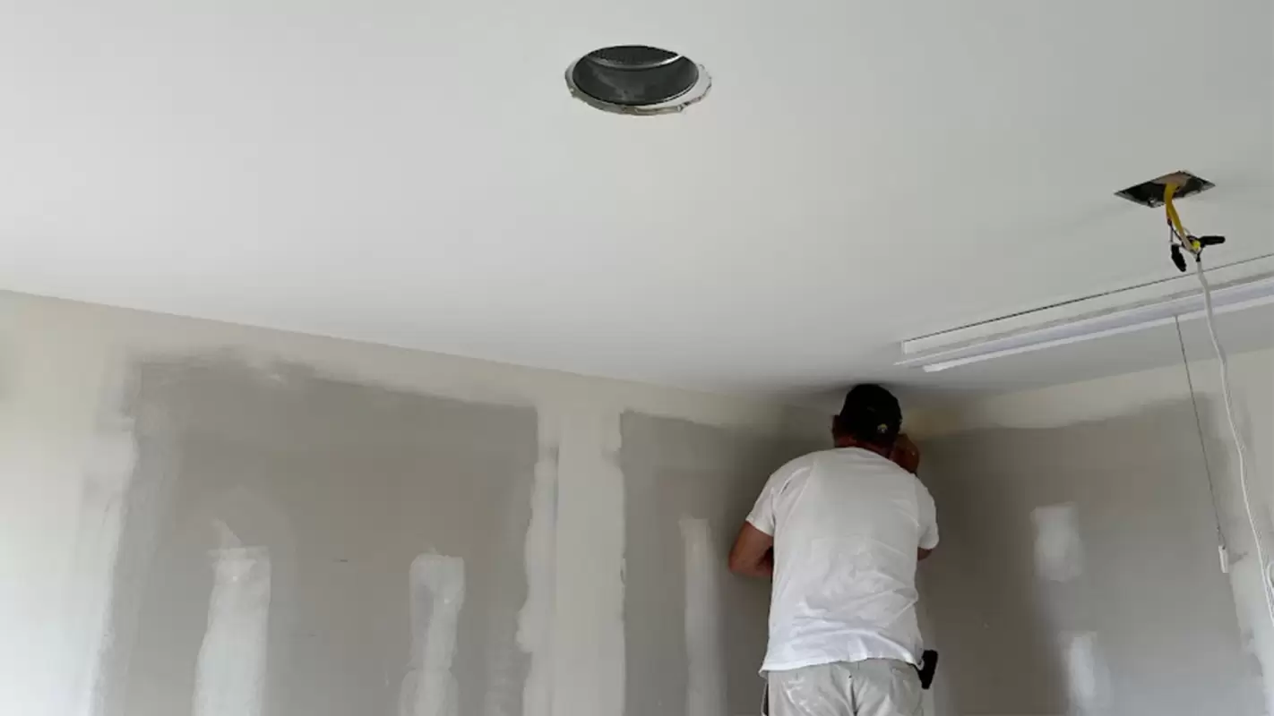 Sanding a repaired ceiling seam and light fixture cutout smooth
